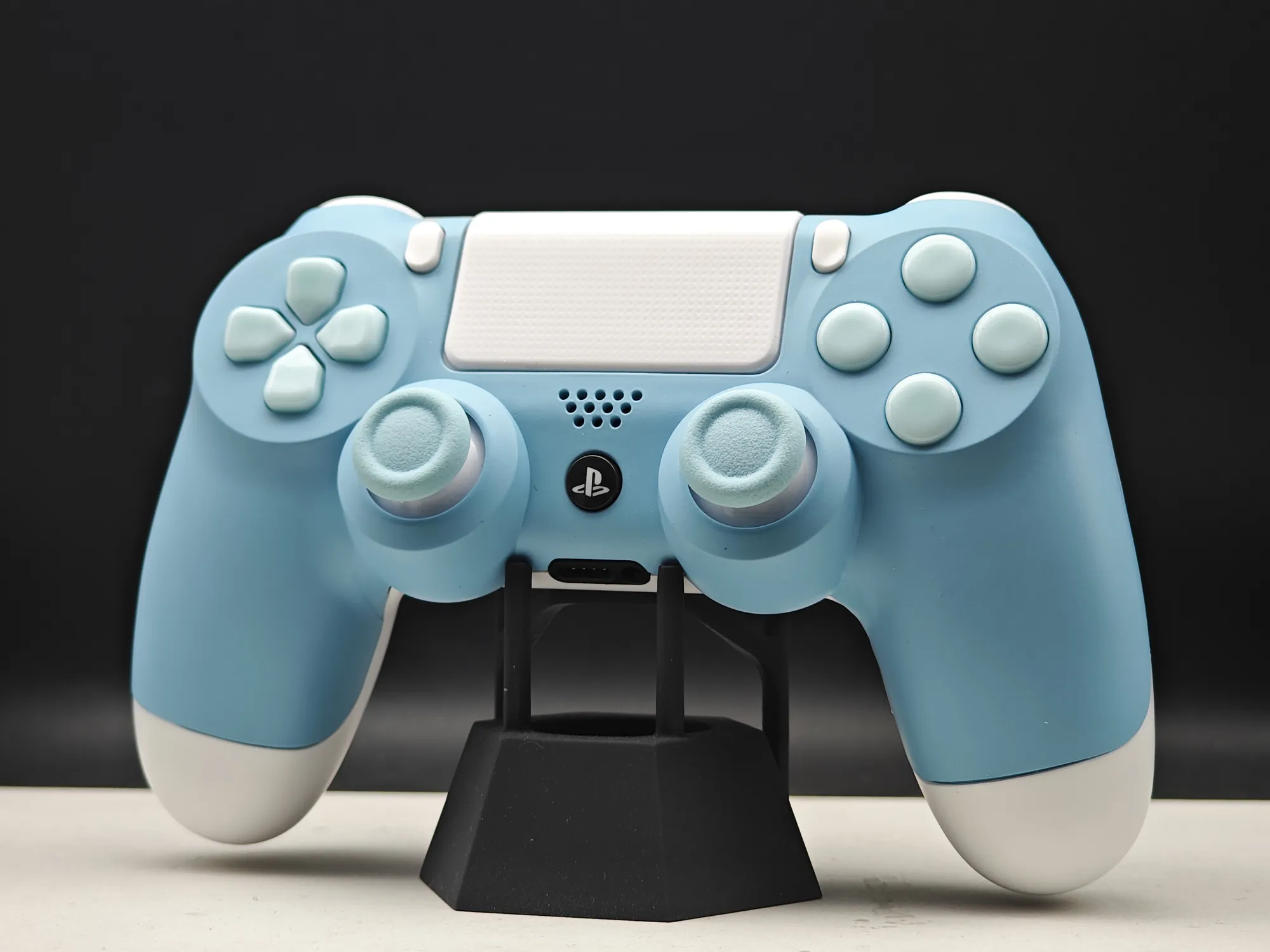 Blue and white custom controller on a black stand